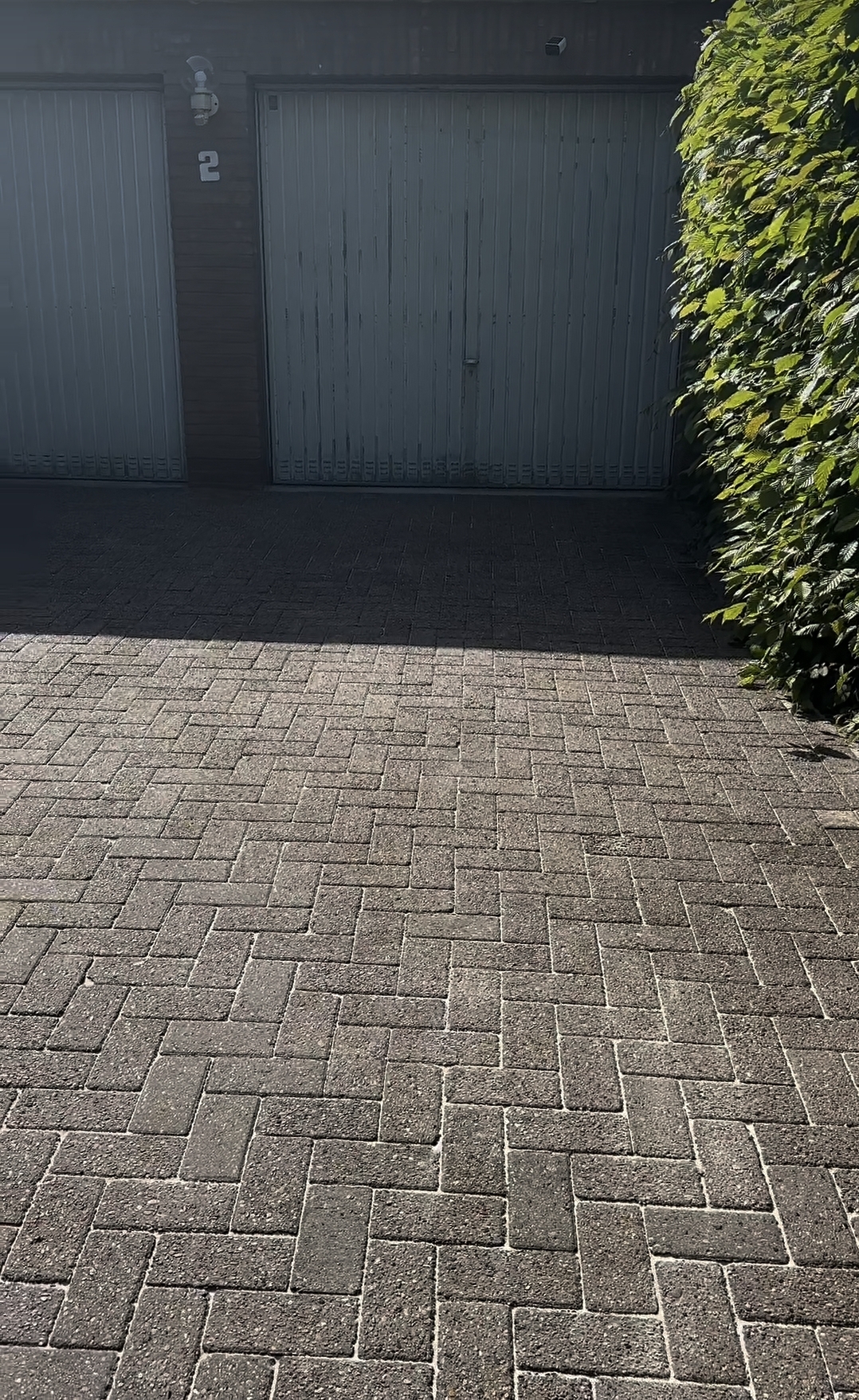 Gereinigte Pflastereinfahrt vor zwei Garagen